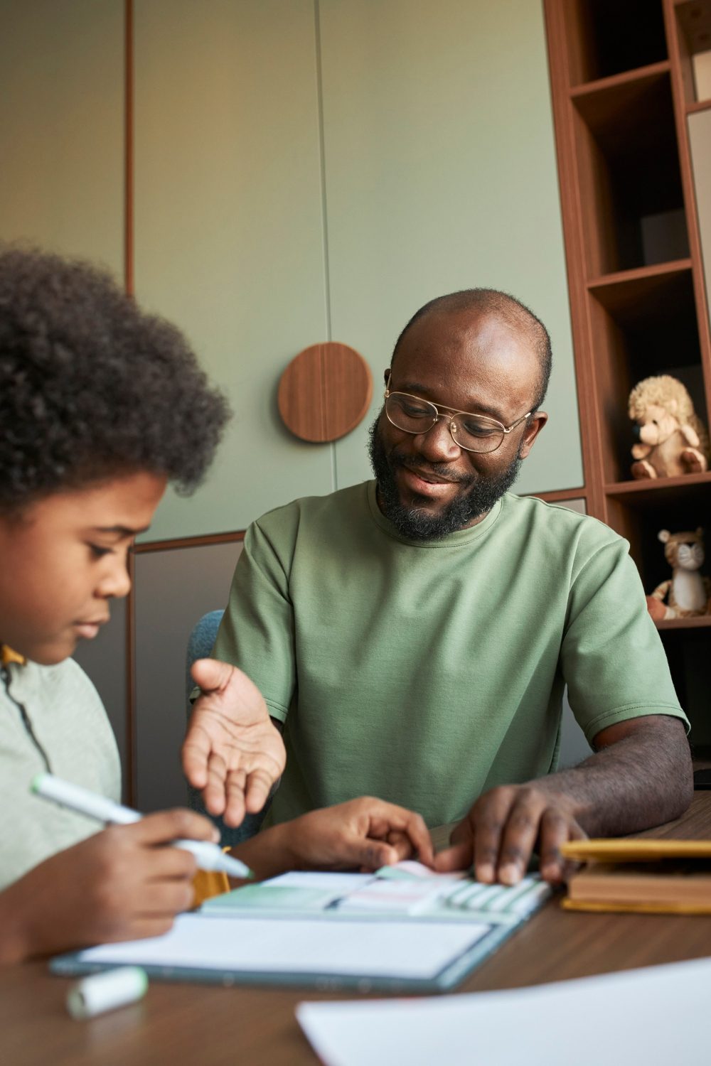 A tutor guides a young learner through maths homework at home.