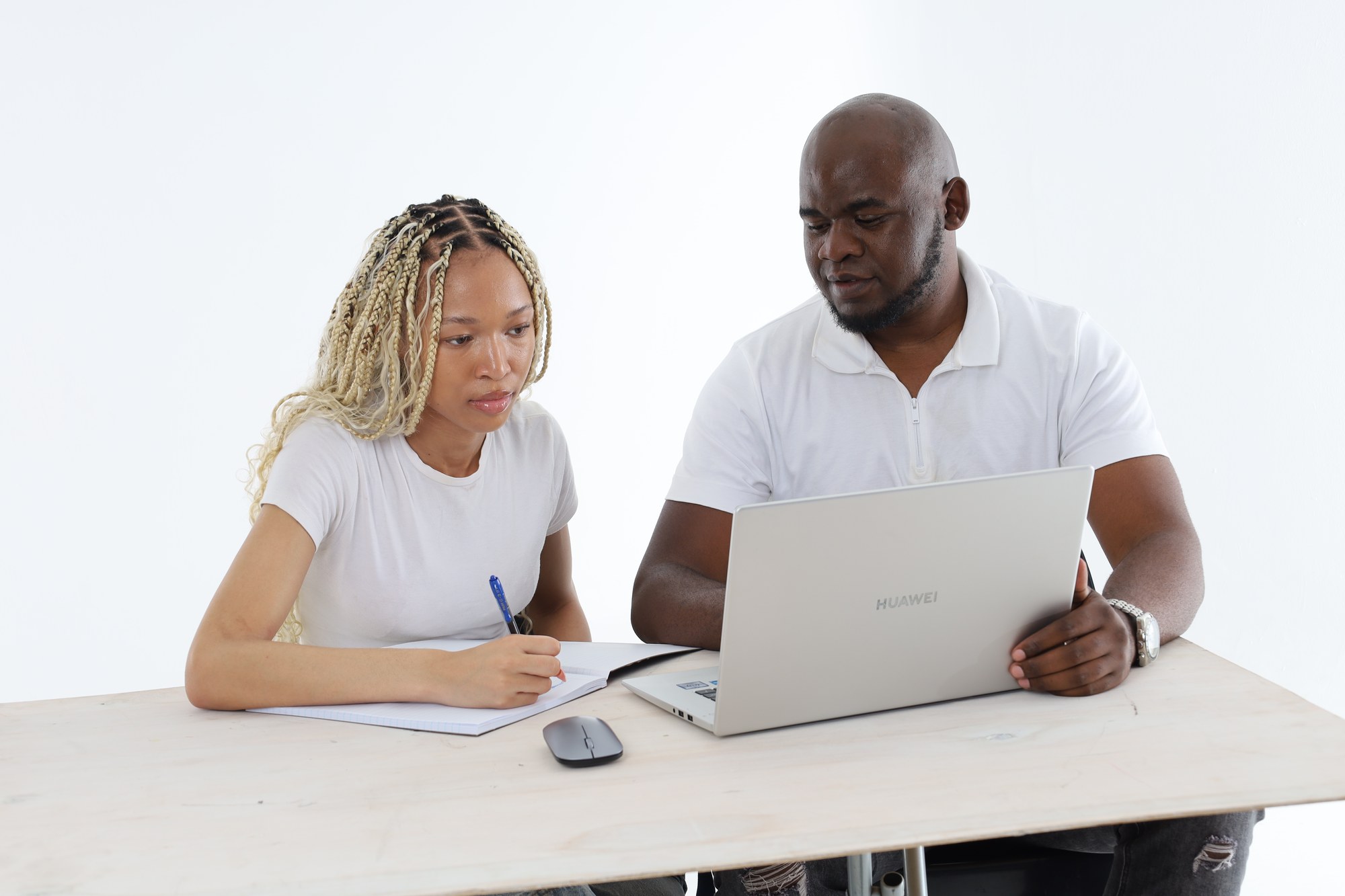 An Apex Academic Centre tutor working one to one with a South African learner who is writing in her book