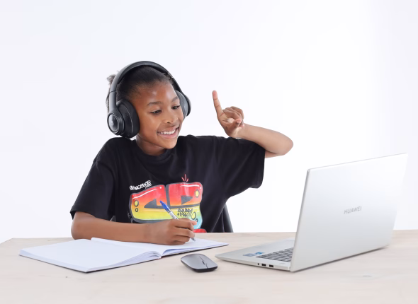 A young South African learner wearing headphones and raising her hand to answer during an online lesson