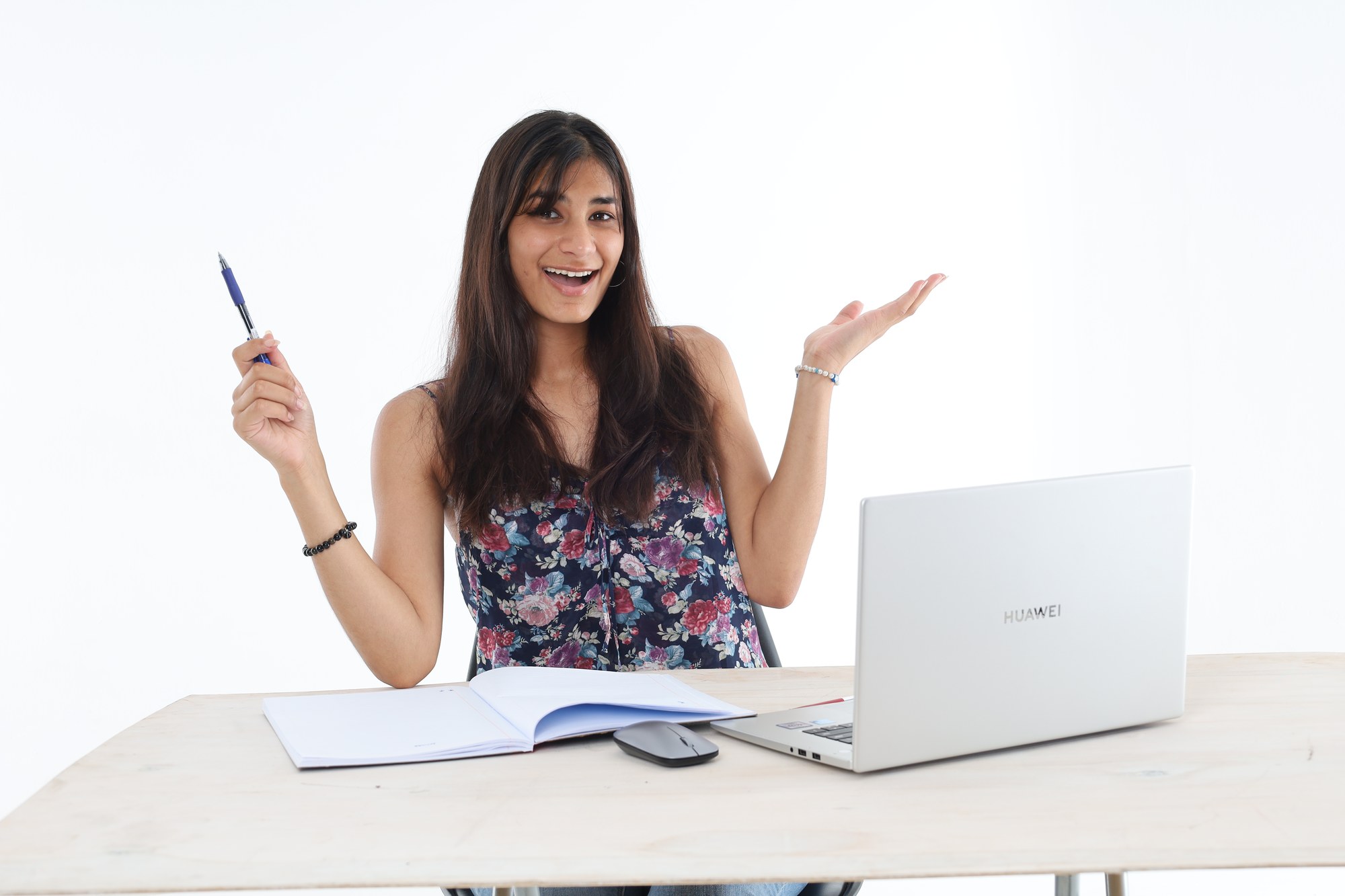 A South African student holding a pen and explaining her working during an online tutoring lesson