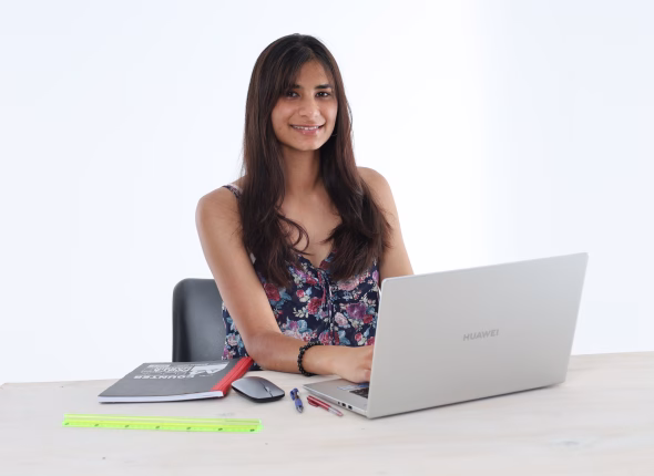 A South African student smiling while working at her laptop during an online lesson