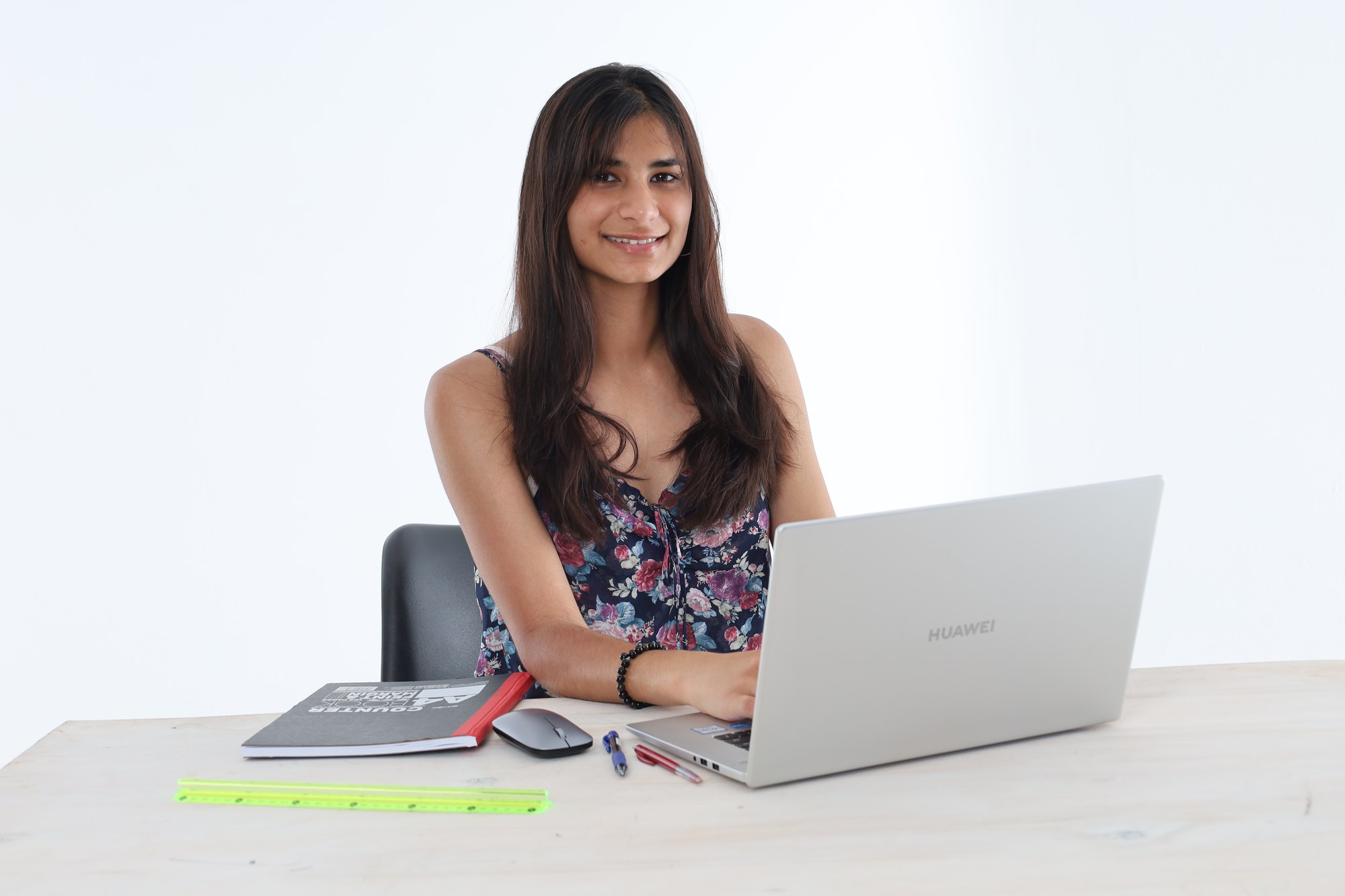 A South African student smiling while working at her laptop during an online lesson