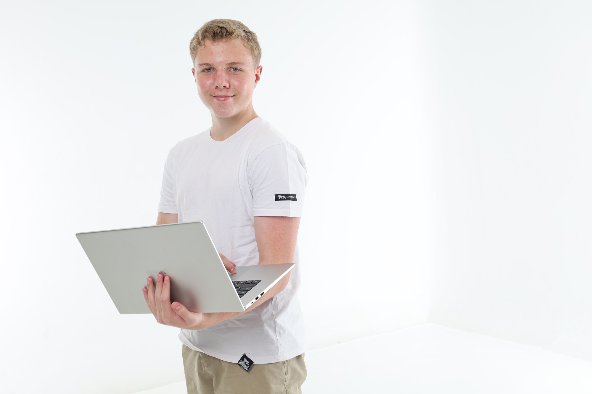 A South African student standing with a laptop, ready to join an online tutoring lesson
