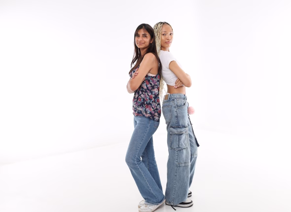 Two South African learners standing back to back and smiling at the camera